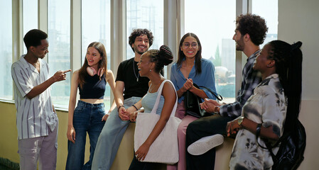 Indian young adult gen z happy boy girl pupil talk casual gossip share blab enjoy new day spend break time campus place. African teen male female group team guys speak funny do joke have fun joy © Raushan_films