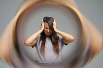 Conceptual image of woman with headache surrounded by blurred tunnel effect