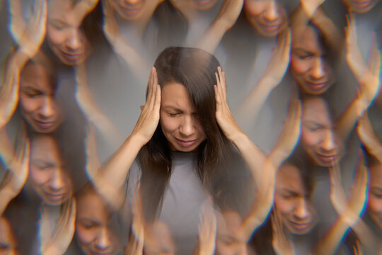 Stressed woman suffering from headache holding her head with hands 