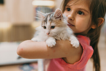 child embraces soft feline lovingly, child lovingly cradles affectionate kitten at adoption event with warmth