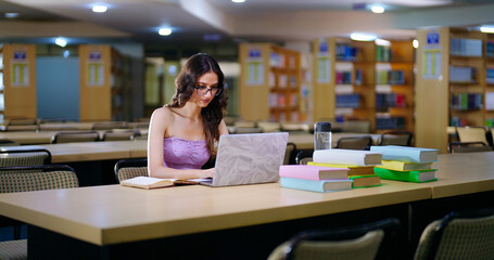 Indian young adult gen z busy student wear glasses sitting on desk table pencil make self study...