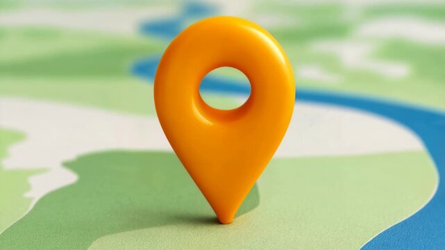 Bright macro style shot of three dimensional map marker resting on simplified map background offering conceptual location footage for navigation delivery logistics local business discovery.