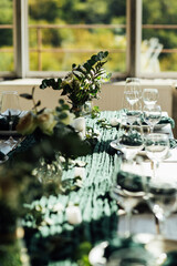 Elegant festive table setting with green decor and glassware