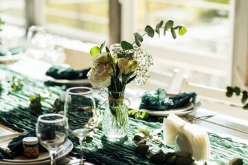 Elegant festive table setting with green decor and glassware
