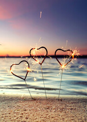 Obraz premium burning sparklers at the beach for happy new year 