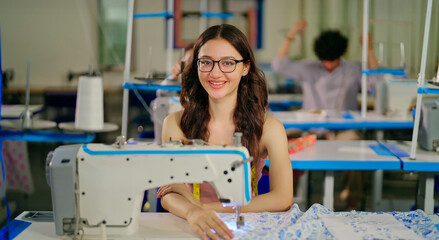 Indian young adult pupil gen z girl wear tape around neck sitting class room learn new good course day. Happy teen female look cam do casual pose do self craft skill sewing machine work indoor place