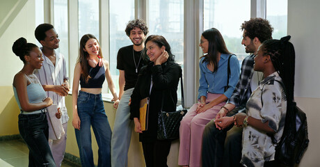 Indian happy young adult tutor lady woman group talk casual gossip have fun joy enjoy new day spend break time indoor place. Teen female girl pupil boy man male guy group mate speak share funny joke © Raushan_films