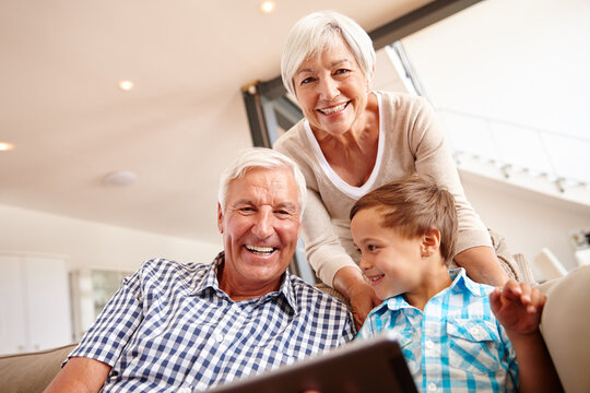 Portrait, grandparents and child with tablet, home and bonding with boy in living room and together. Happy, senior man and old woman with kid on couch, family and elderly people with smile in lounge