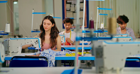 Indian young adult pupil gen z woman wear measure tape around neck sitting class room learn new casual course good sewing machine focused female girl do self craft skill indoor day college place