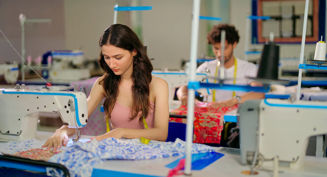 Indian young adult pupil gen z woman wear measure tape around neck sitting class room learn new casual course good sewing machine. focused teen female girl do self craft skill indoor day college place - Powered by Adobe