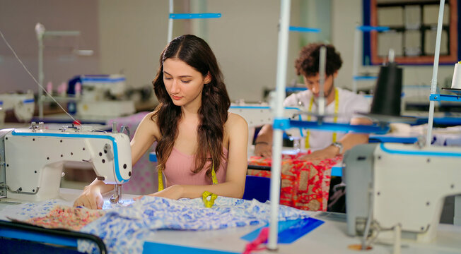 Indian young adult pupil gen z woman wear measure tape around neck sitting class room learn new casual course good sewing machine. focused teen female girl do self craft skill indoor day college place - Powered by Adobe