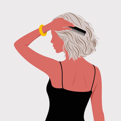 A stylish woman with wavy hair is grooming her curls with a comb, wearing a simple black dress, capturing an essence of self-care and confidence.