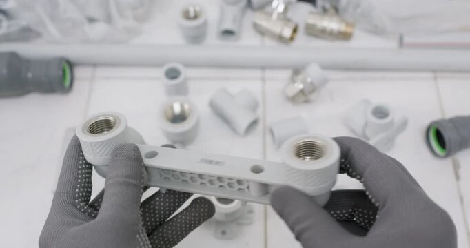 Installer aligns twin outlet bracket for mixer connection on board. Professional worker indicates center distance and positions wall mount verifying level