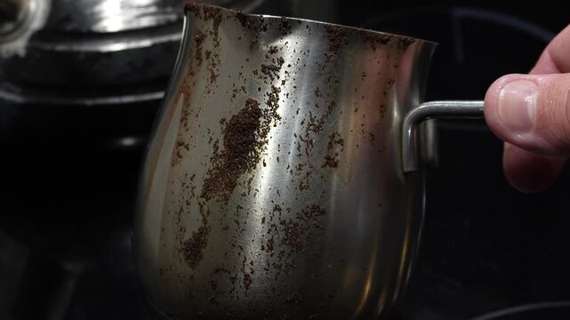 Morning coffee in a Turkish cezve. Making coffee. A cezve with spilled coffee.