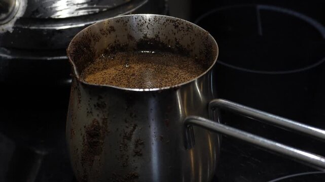 Morning coffee in a Turkish cezve. Making coffee. A cezve with spilled coffee.