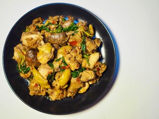 Stir-fried chicken with basil in a plate placed on a white background. Spicy and delicious Thai food.