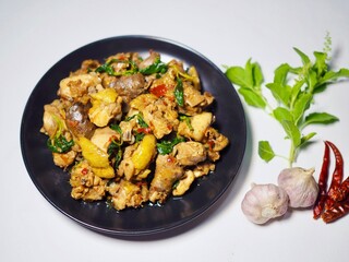 Stir-fried chicken with basil in a plate placed on a white background. Spicy and delicious Thai food.