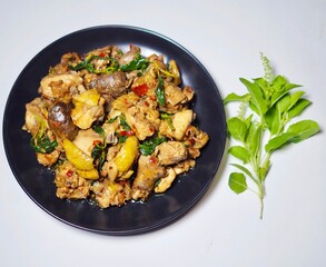 Stir-fried chicken with basil in a plate placed on a white background. Spicy and delicious Thai food.