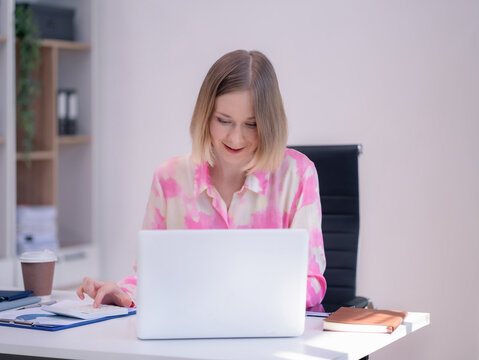 Caucasian businesswoman working at office with laptop and documents on his desk, financial adviser analyzing data.