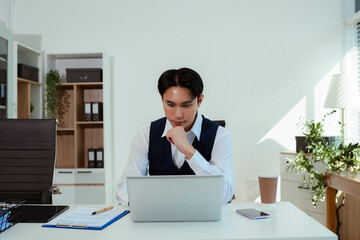 Naklejka premium pleasant looking successful professional male business accountant learns clients case, works on modern laptop and smartphone.