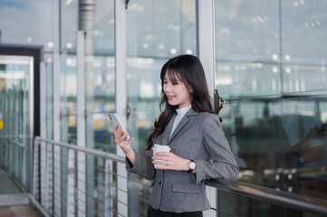 Fototapeta premium Asian businesswoman checking smartphone while traveling
