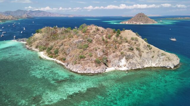 Drone perspective of Pulau Kelor Komodo surrounded by tropical ocean and lush coastline