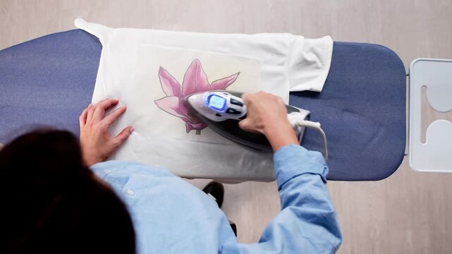 Woman Doing T Shirt Print Transfer Using Iron Appliance