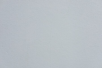 A smooth, light gray textured wall surface. The wall has a subtle, uniform appearance with no visible patterns or markings.