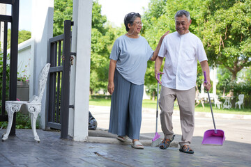 Senior Couple Cleaning Outdoor Area Together, Elderly Man And Woman Sweeping Front Yard, Happy...