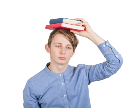 Exhausted teenage guy keeps books on his head has to prepare for exams and feeling overwhelmed, depressed. Concept of difficult education