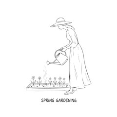 Obraz premium A woman watering flowers in a garden. Spring Gardening. The woman is wearing a hat and a long dress