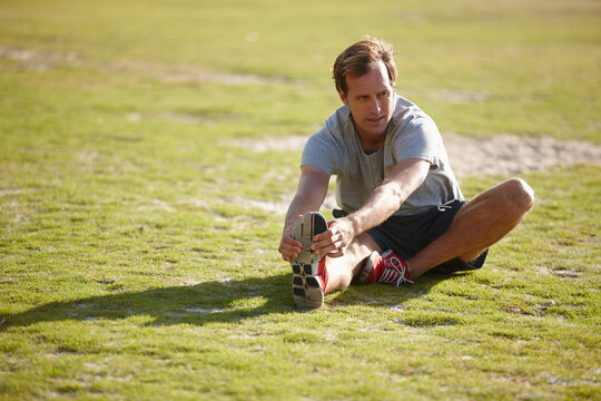 Outdoor, stretching and man with fitness, training and warm up with morning routine. Start day, athlete and healthy person with exercise, workout and practice with wellness, grass field and challenge - Powered by Adobe