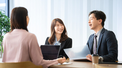 Obraz premium 打ち合わせをする男女3人のビジネスマン