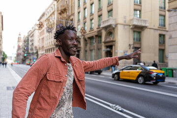 Black man hailing taxi in Barcelona city street for urban travel and transportation