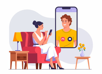 A woman is engaged in a video call, highlighting connection and communication, enjoying the comforts of her stylish living room adorned with warm furnishings and decor.