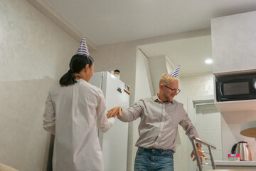 Birthday Party Elderly Man Woman Home: Celebrating senior's birthday indoors with family; joyful moment captured.