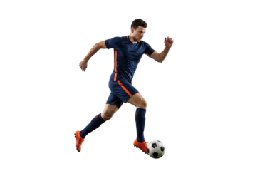 Male soccer player dribbling ball in mid stride on isolated black background, athletic action and competitive sports concept for training, fitness and team game promotion