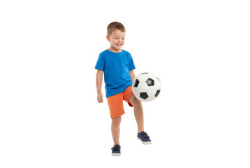 Fototapeta premium Young boy juggling a soccer ball on isolated background, active childhood play and beginner football skills for youth sports training and physical education concepts