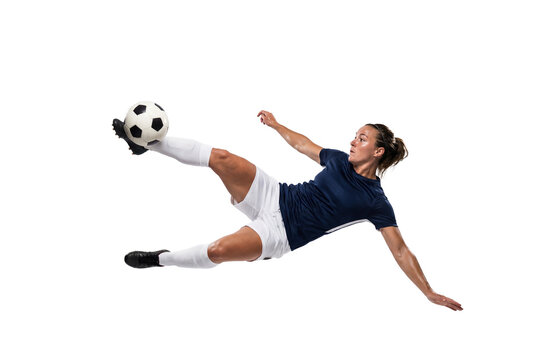 Female soccer player performing airborne bicycle kick on isolated black background, athletic action and competitive sports concept for training, fitness motivation and team game promotion