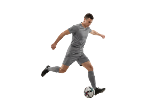 Male soccer player kicking ball in motion on isolated background, athletic action and competitive sports training concept for fitness promotion and game strategy visuals