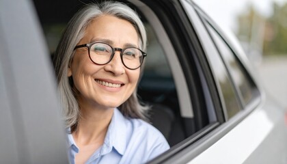 Happy senior woman smiles in car. Elderly female with glasses enjoys road trip, travels in vehicle. Retirement