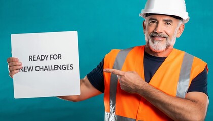 Mature construction worker in safety gear holding a "Ready for New Challenges" sign on a turquoise background, concept for career development, job search and professional growth