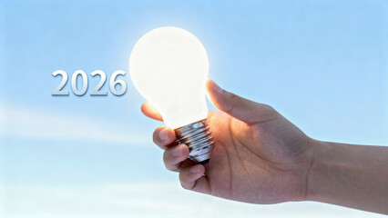 Hand holding lightbulb symbolizes hopeful innovation creativity and new technology for bright future in 2026