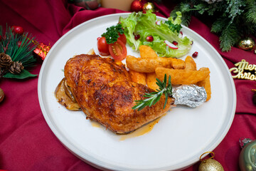 A Deliciously plated roasted chicken meal with french fries and a small salad, beautifully arranged. The vibrant colors and textures make the dish appealing.