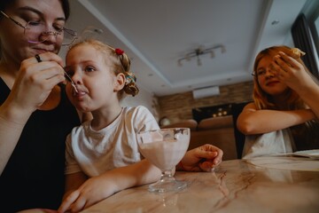 A cheerful 4-year-old girl prepares for breakfast in a bright morning living room. Authentic childhood moment of family routine and natural morning energy