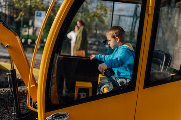 Boy playing driving toy excavator machine © Ljustina