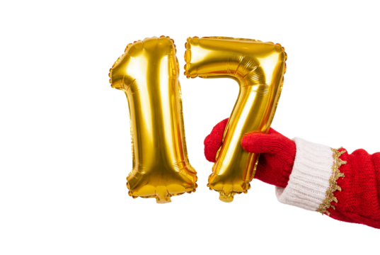 Hand in red winter mitten holding gold foil balloons forming number 17 on white background, festive birthday or anniversary celebration concept for party decor and milestone events