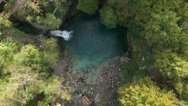 Blue Eye with crystal clear water pond and waterfall surrounded by Albanian mountains and hike trails