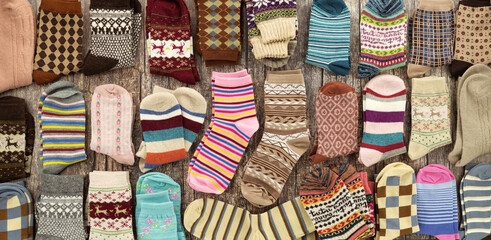 A close-up of rolls of various fabrics. Sewing fabric is folded in a pile. The textiles are of different types and colors.