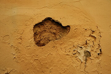 Trou dans un mur beige.